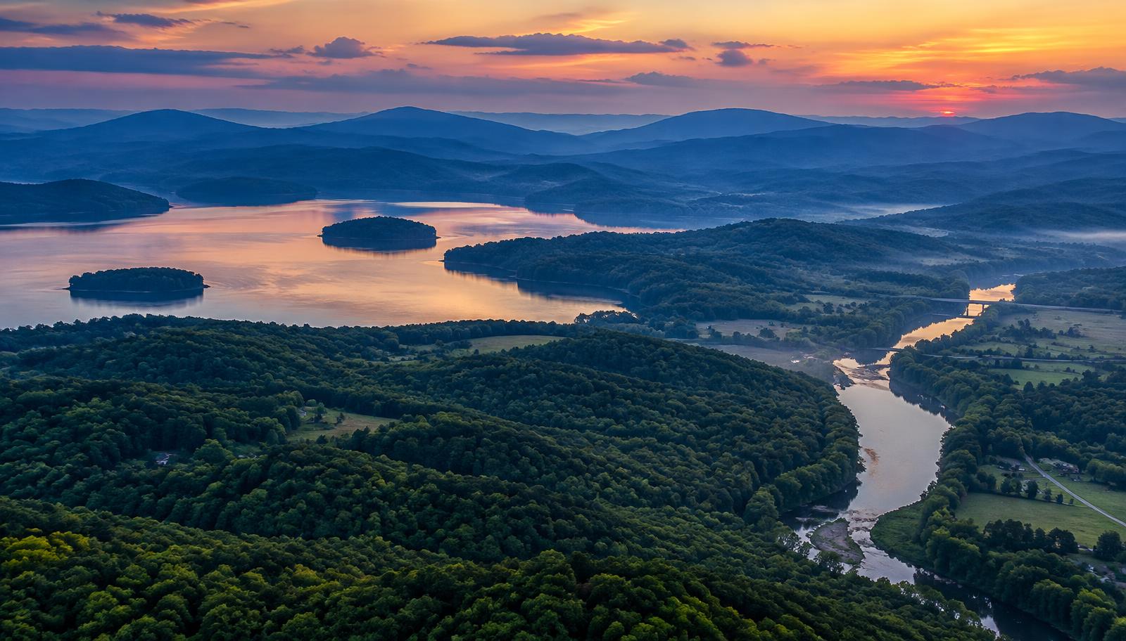 Aerial view of rolling North Georgia hills, lake and river valley near Bartow County at sunset